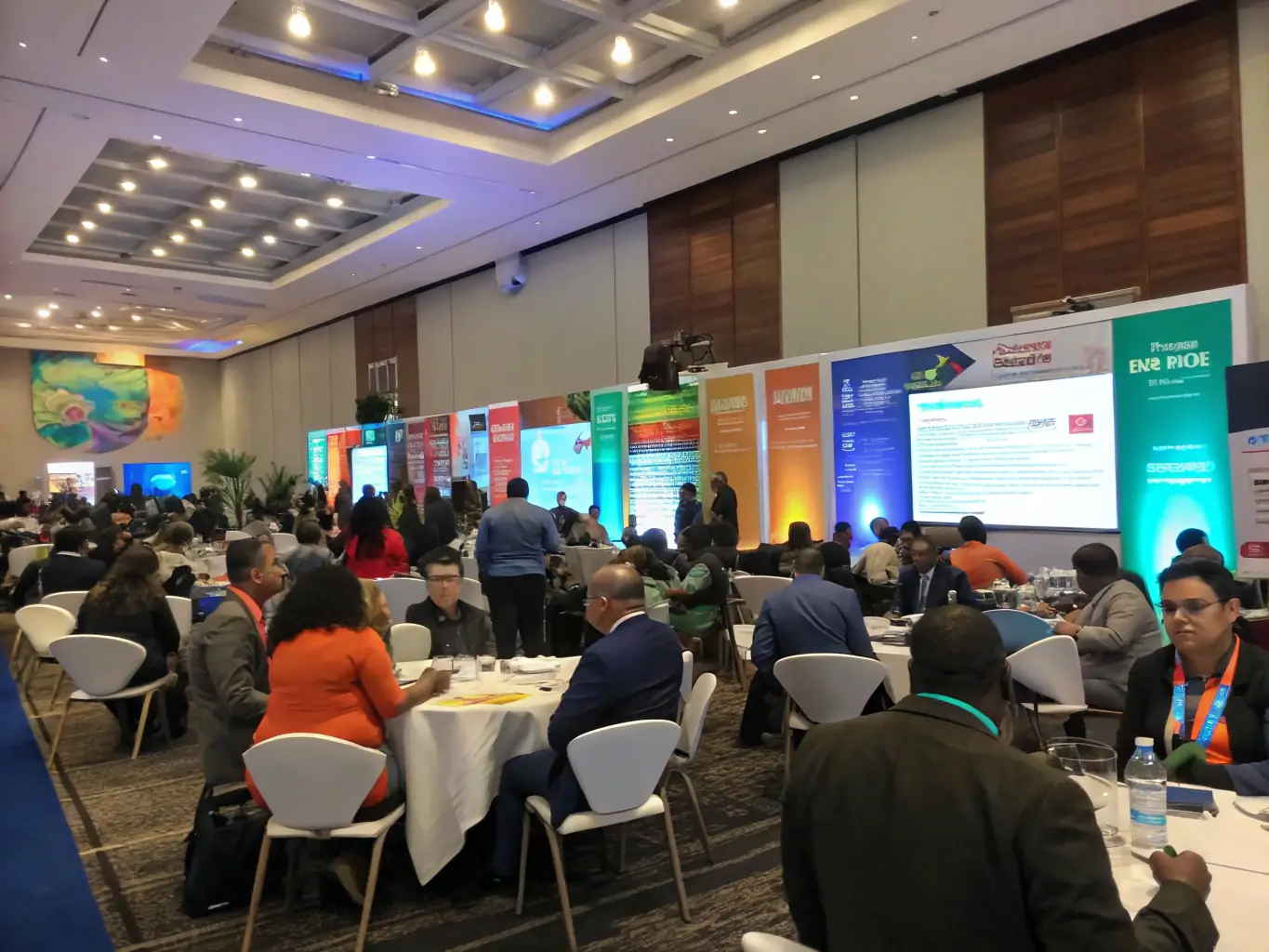 A dynamic photograph capturing a cultural conference in full swing, with speakers on stage, attendees actively listening, and engaging discussions taking place.